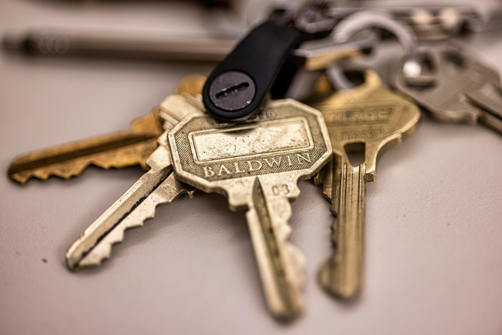 A single set of keys resting on a wooden desk, symbolizing the moment of closing on a new property investment.